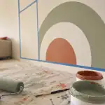 Fresque murale facile à faire avec ruban et formes organiques sur mur blanc.